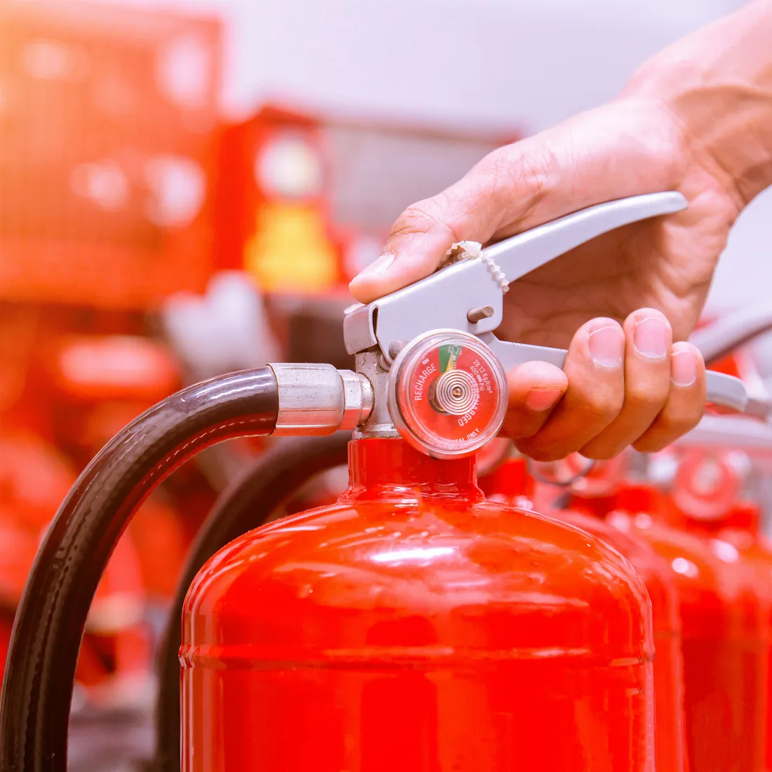 Sachkundiger Brandschutztechniker fuehrt Wartung an Feuerloescher nach DIN 14406-4 durch